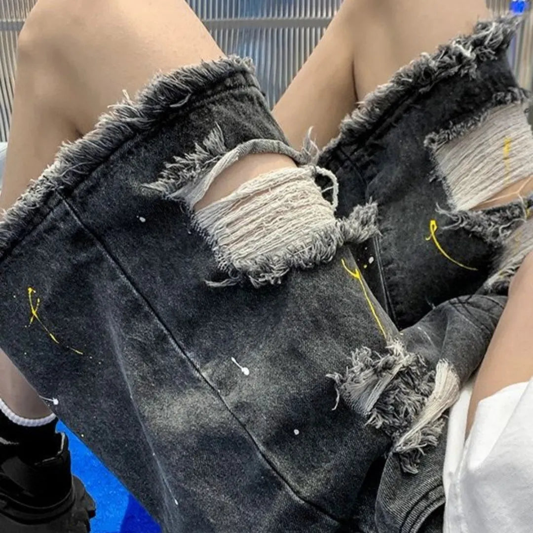 Men's loose fit light blue denim shorts with a water washed finish and hole detailing on a solid background.