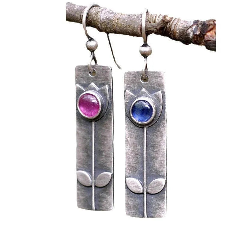 Pair of women's antique finish earrings with red sapphires, geometric shape, and ellipse design on a retro electroplated metal setting.