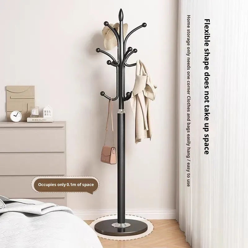 Floor-standing iron coat rack in black with vertical metal frame for hanging jackets and bags in a bedroom or hallway