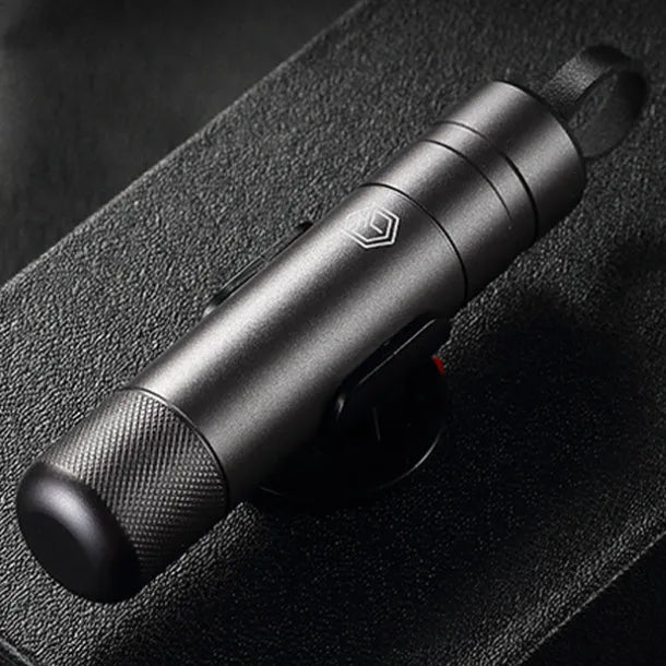 Gun grey aluminium automobile safety hammer with bearing steel impact head on a 3M rubber base next to a test glass piece.