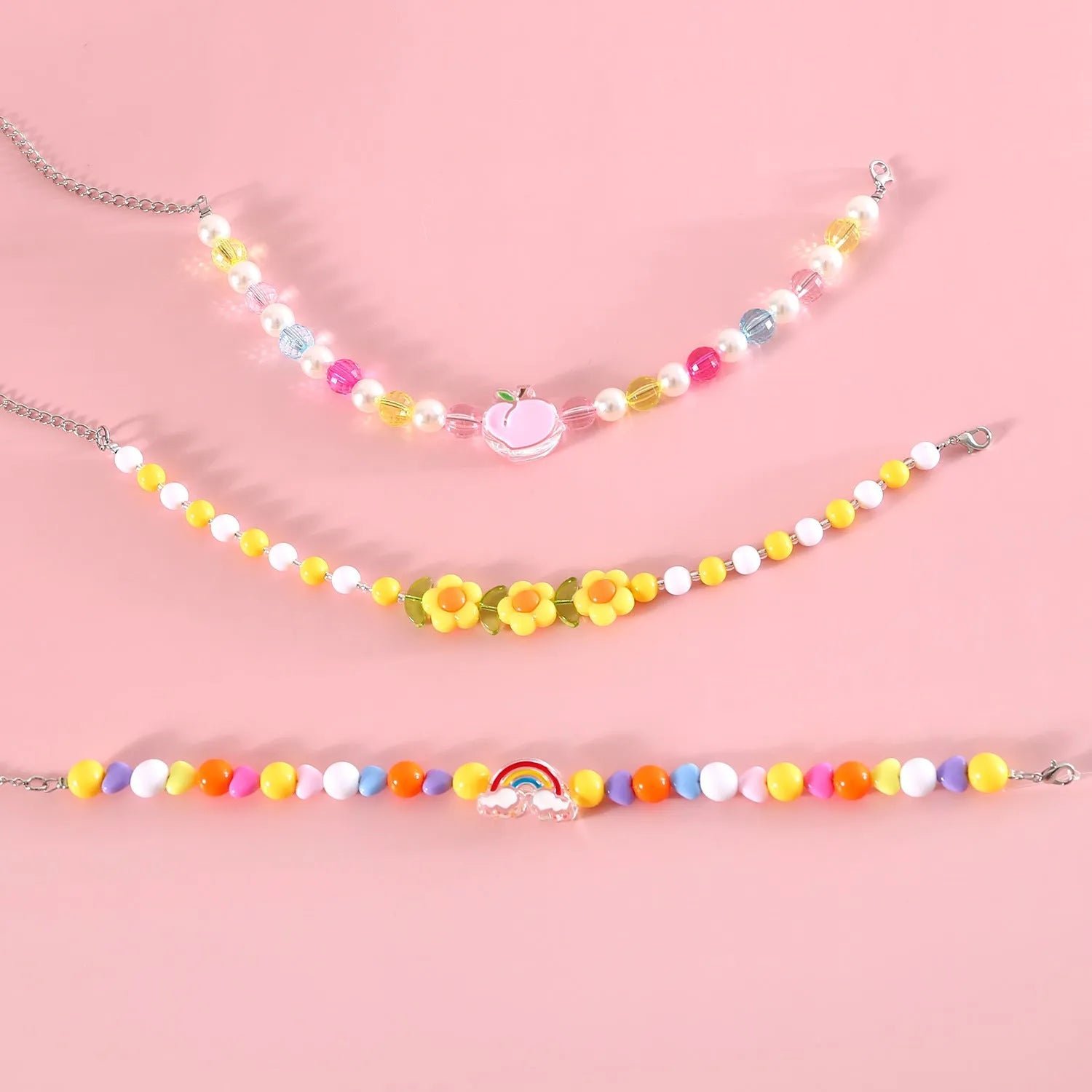Colourful plastic bead cat necklace in small flower, rainbow, or peach design on a cat.