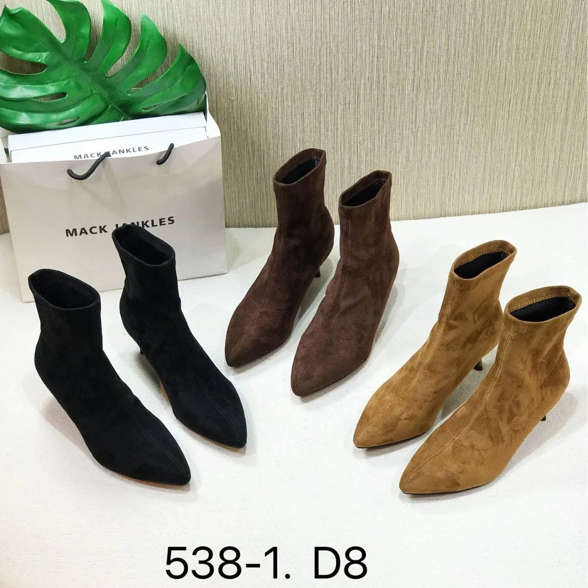 Black pointed toe women's ankle boots with a high stiletto heel on a rubber sole.