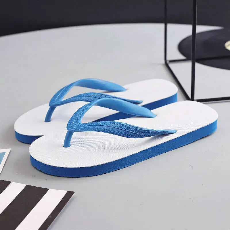 Men's rubber flip-flops in black with a fish logo, showing non-slip sole tread.
