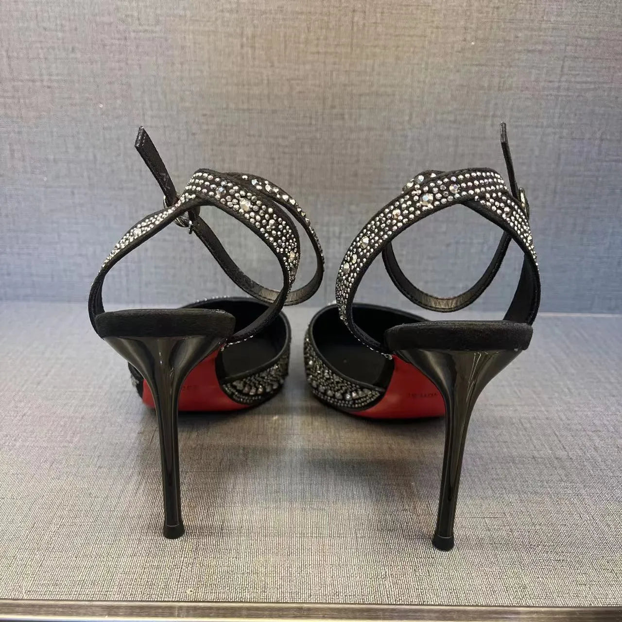 Women's black stiletto high heels with red sole and pointed toe design