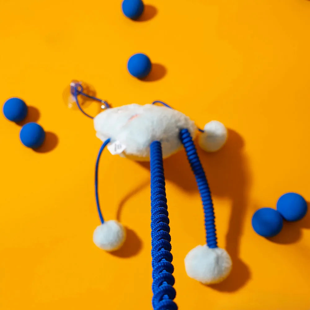 Blue plush ring cat toy with elastic rope and a mint-coloured bell, shown on a white background.