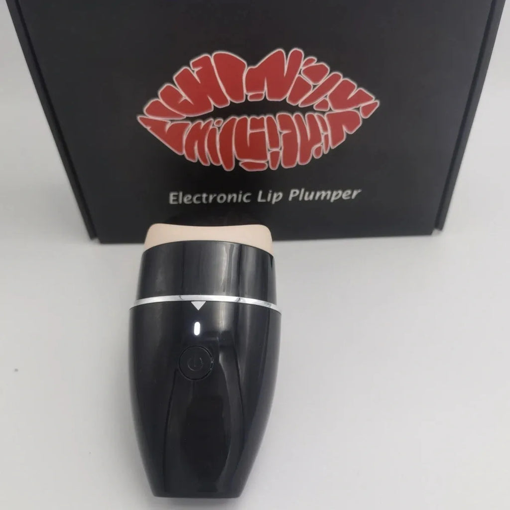 Black and white electric lip plumper device with USB charging cable on a plain background.