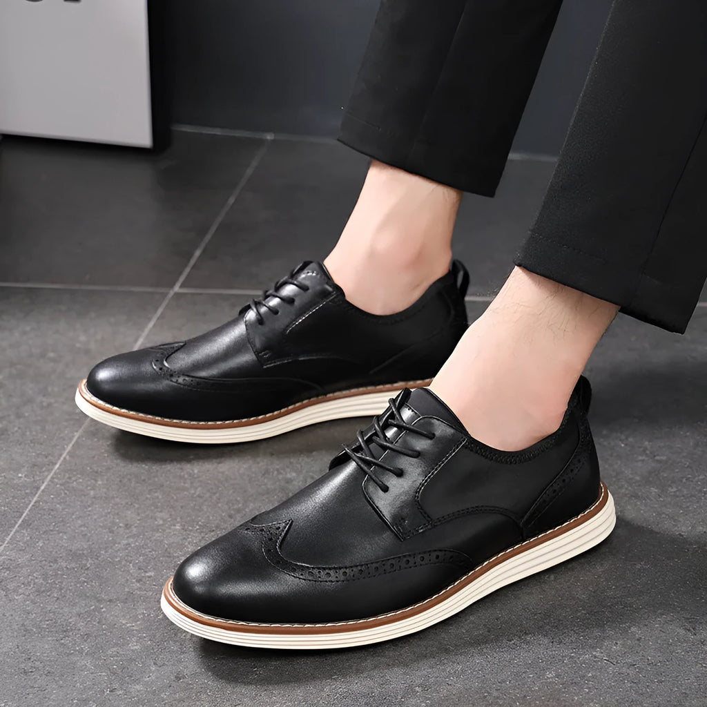 Men's black slip-on business casual shoes with round toe and carved sole detail on a white background.