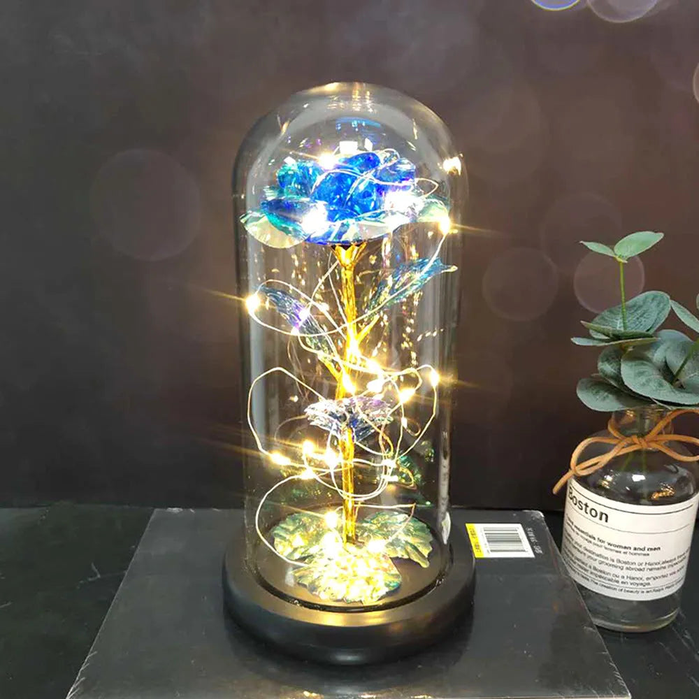 Simulated pink silk rose inside a glass dome with glowing LED fairy lights