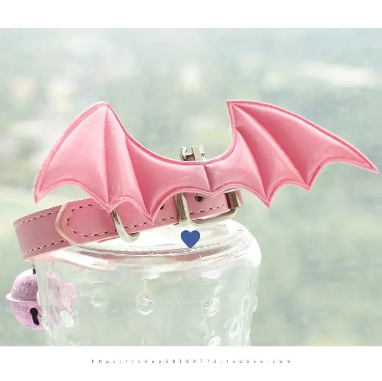 Small black patent leather dog collar with little devil wings charm and bell attached.
