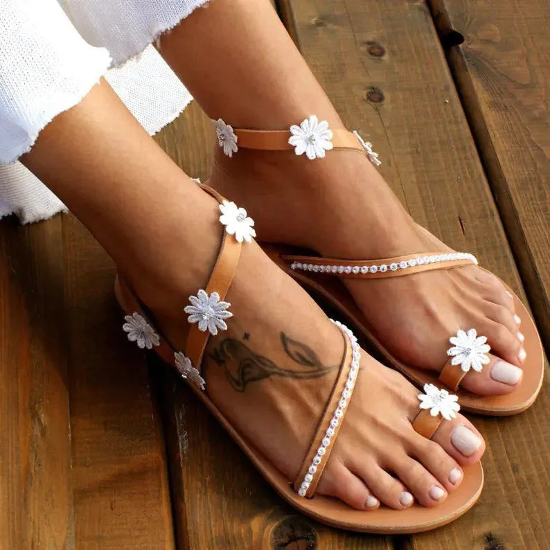 Brown women's Roman sandals with floral decoration and a flat rubber sole