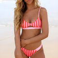 Women's black and white dot polyester bikini set laid flat, showing top and bottom pieces.