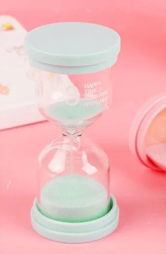 Handmade glass sand timer with blue sand, showing modern minimalist hourglass design.