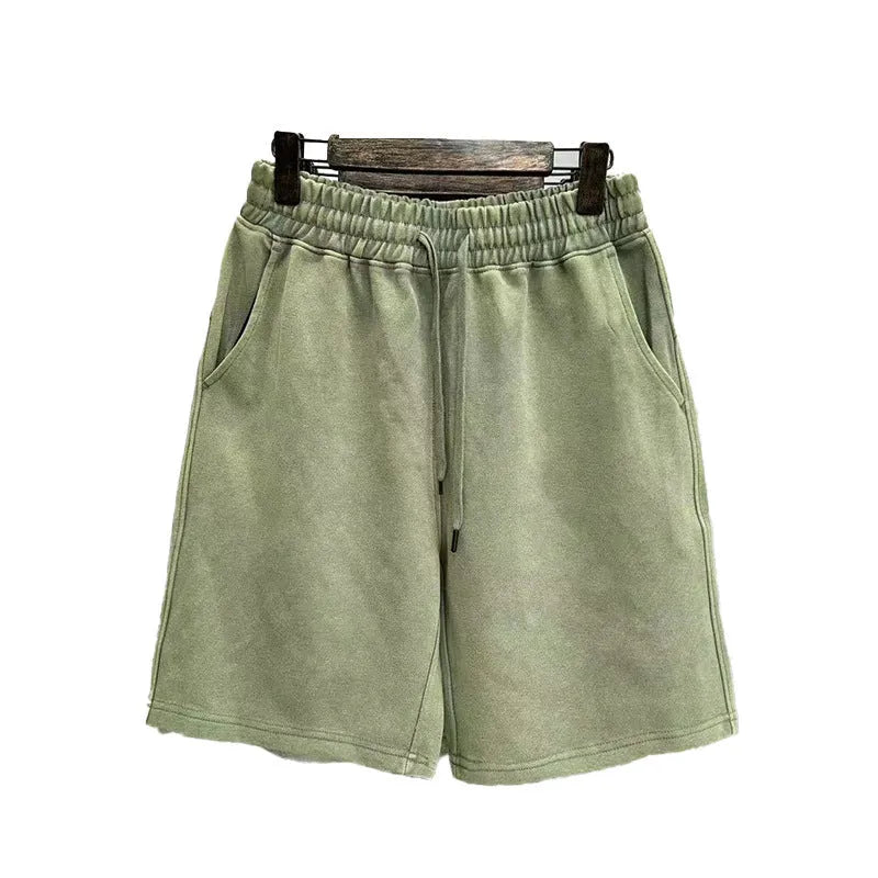 Man wearing charcoal black distressed cotton casual shorts with a loose straight fit.