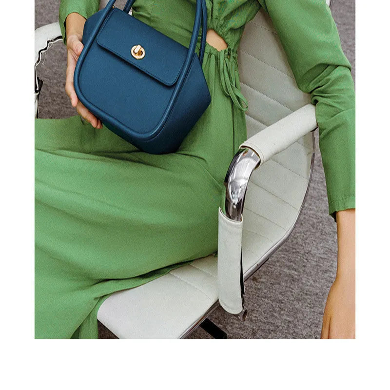 Women's wing-shaped leather tote bag with latch closure and cross-body strap in four colour options
