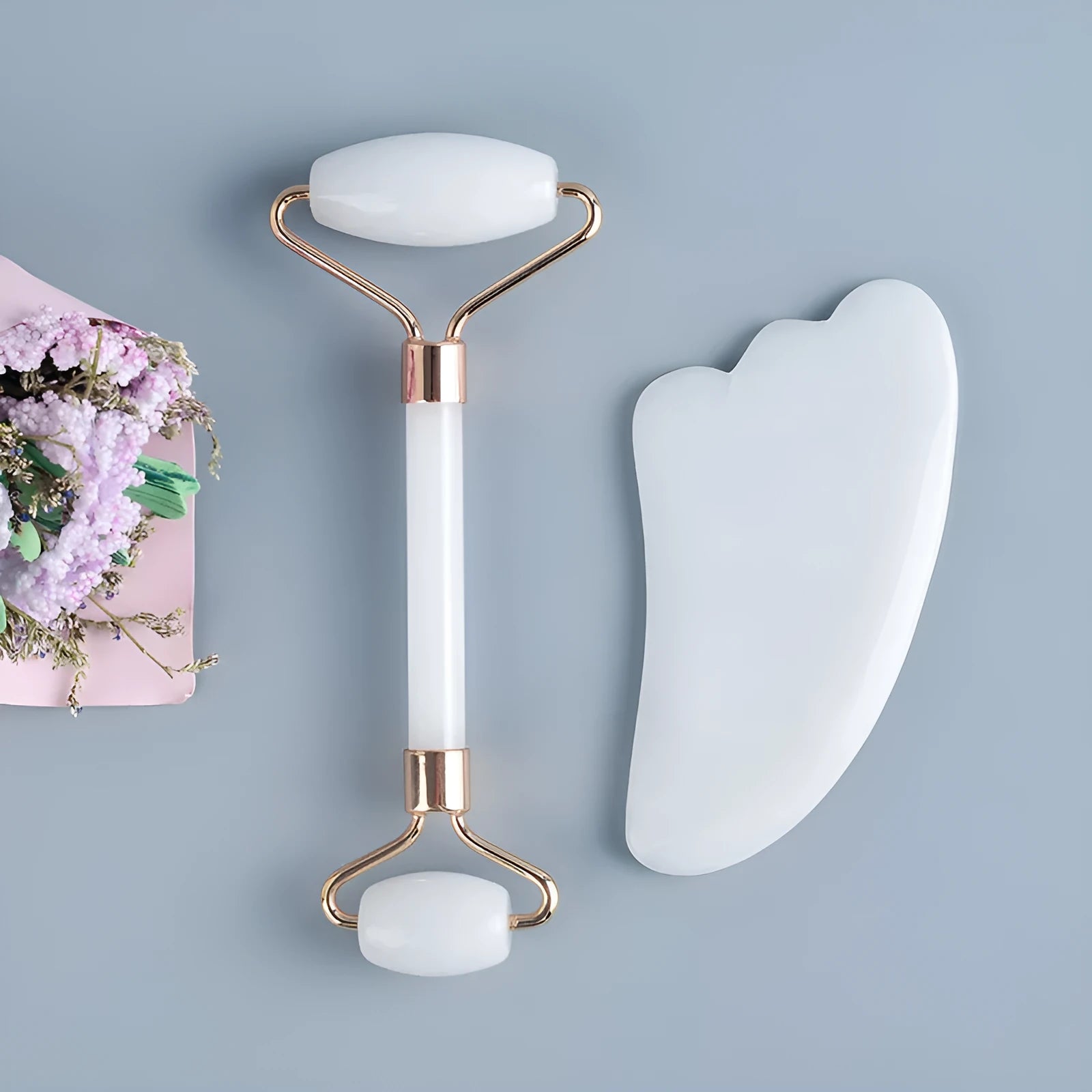 White jade double-headed facial roller and gua sha scraping tool set with a wooden storage board.