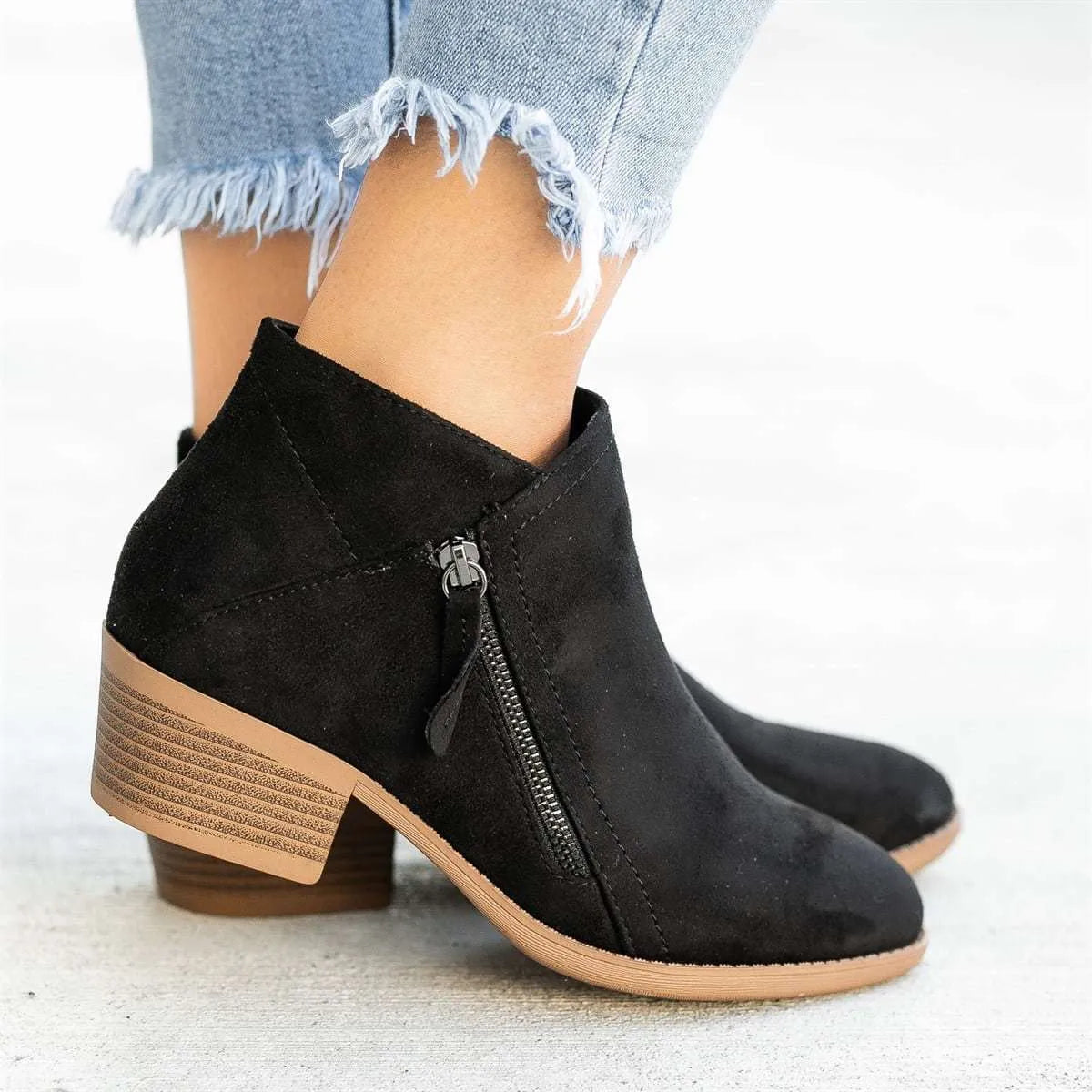 Blue Dr Martens women's suede ankle boots with a side zip and chunky heel on a white background.
