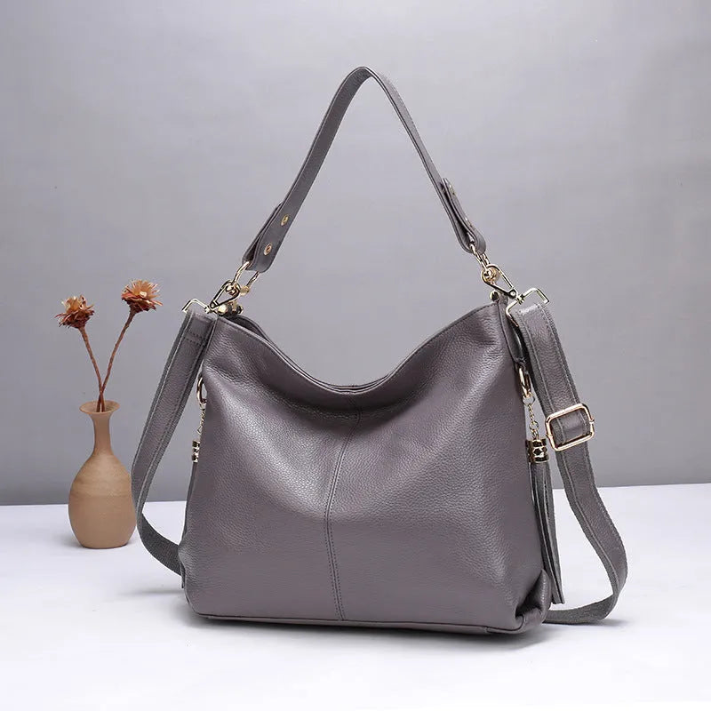 Genuine leather crossbody bag showing vertical square shape and internal compartments for phone and documents