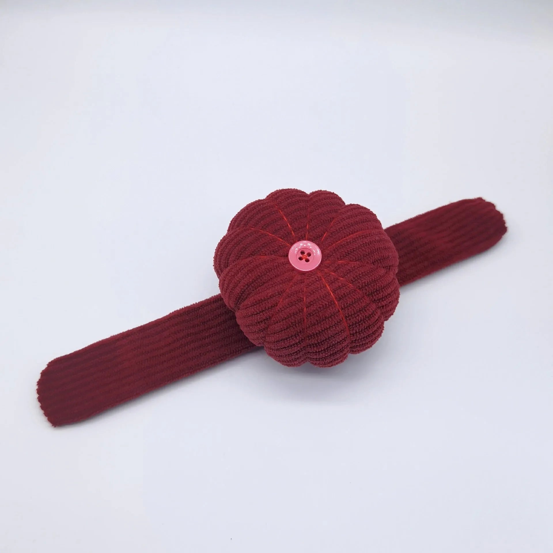 Ring pincushion sewing tool with vertical cutting slot in caramel colour showing fabric cushion and metal ring base