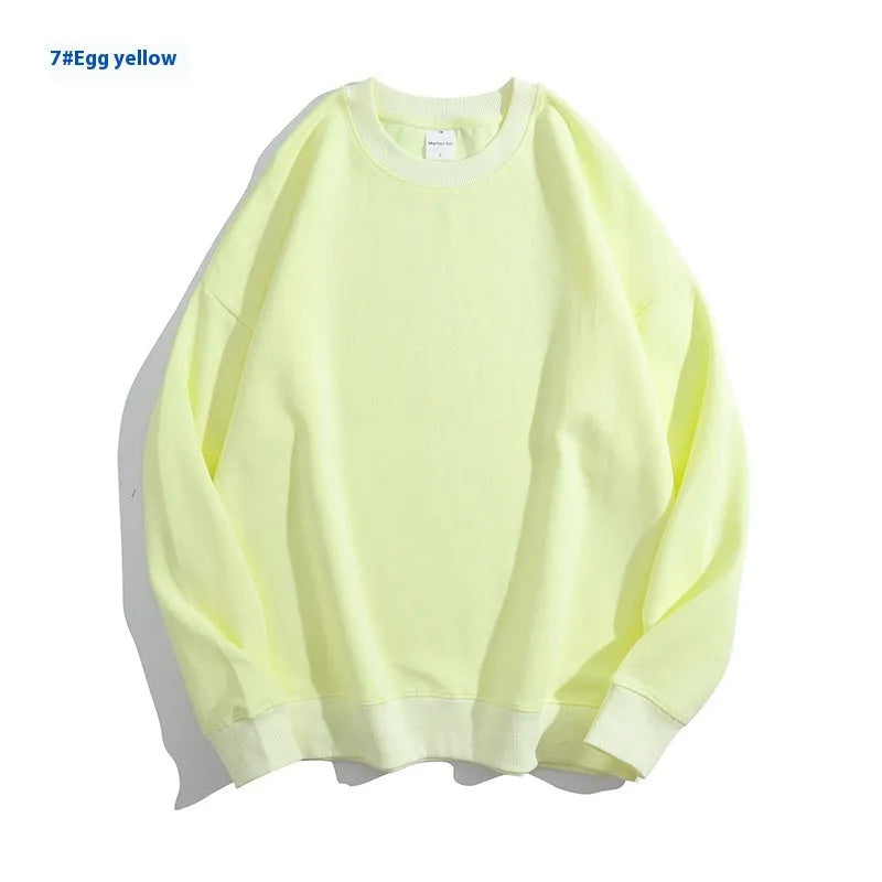 A loose-fitting, off-shoulder cotton sweater in a solid colour with long sleeves and a round neck.