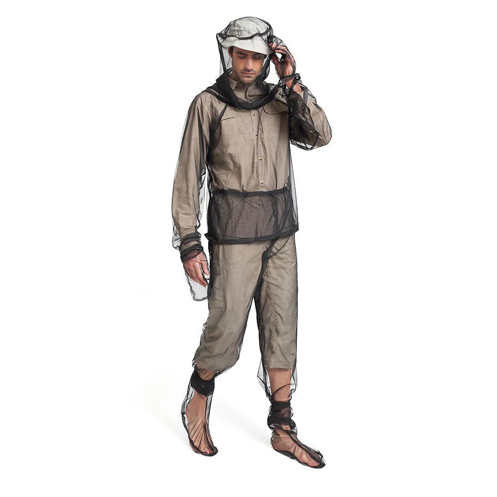 Adult wearing a light grey mesh anti-mosquito suit with hood, full-length pants, and booties for outdoor protection.