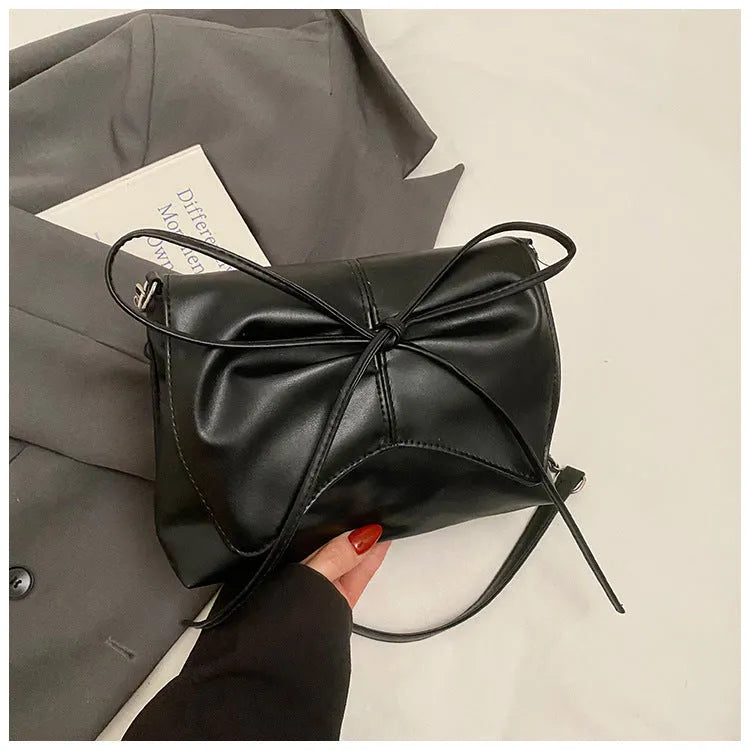 Women's black PU leather crossbody bag with horizontal square shape and visible sewing details