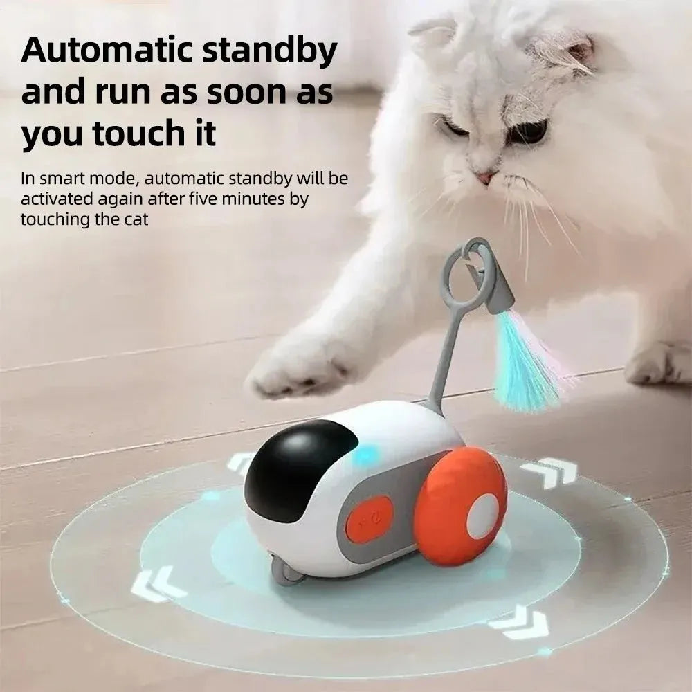 Blue or orange smart electronic cat toy car with feather teaser and remote control on floor.