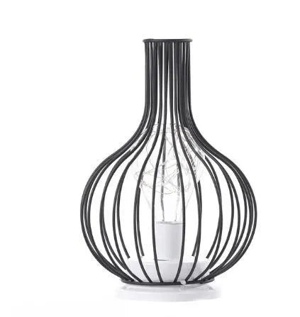 Minimalist hollow iron table lamp in red wine glass style on a wooden desk.
