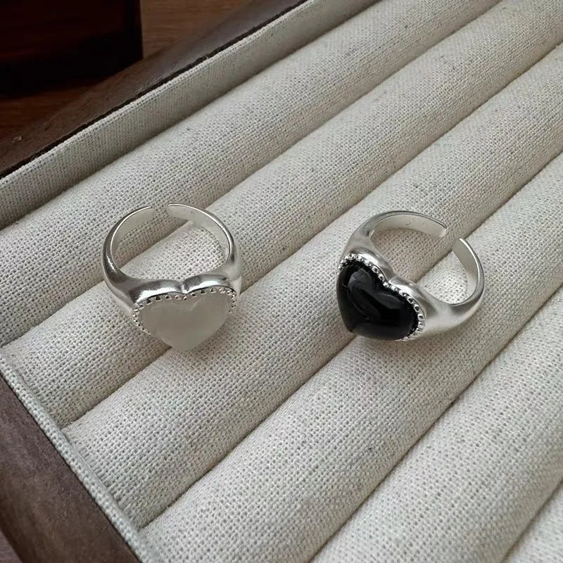 S925 sterling silver adjustable ring with a black agate heart design on a finger.