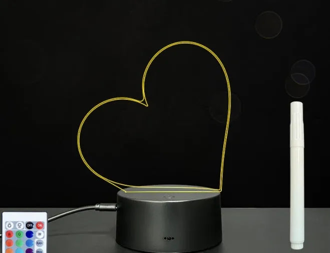 Black 3D LED handwritten acrylic message board with remote control on a desk.