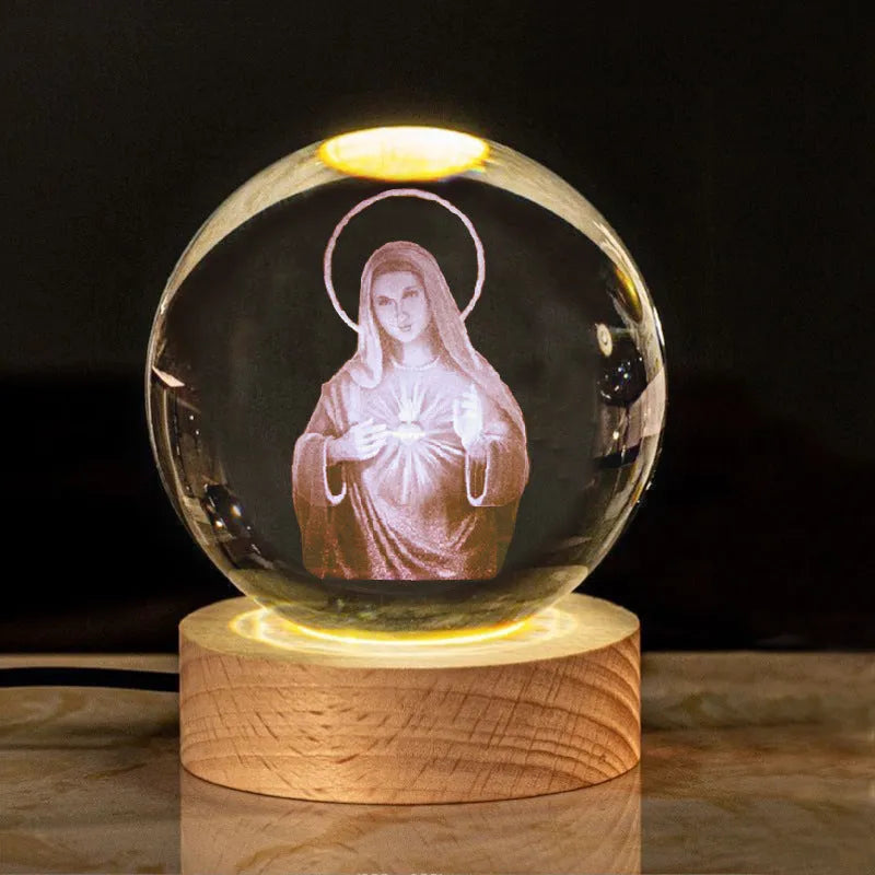 White crystal ball ornament on wood base with warm light and religious symbols