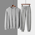Men's light gray hooded cashmere sweatshirt and matching trousers laid flat as a set.