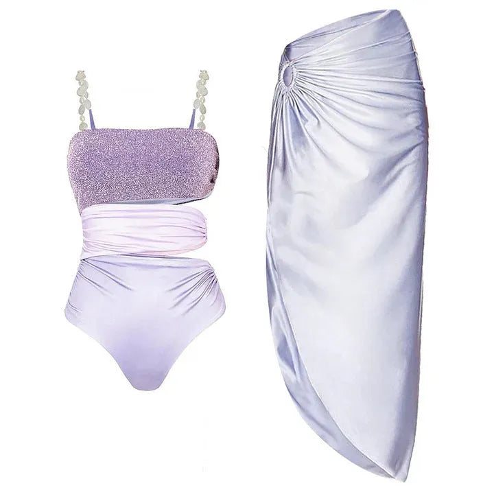 Purple one-piece swimsuit with a separate matching wrap skirt laid flat.