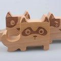 Beech wood mobile phone holder stand with coin slot and decorative carving.