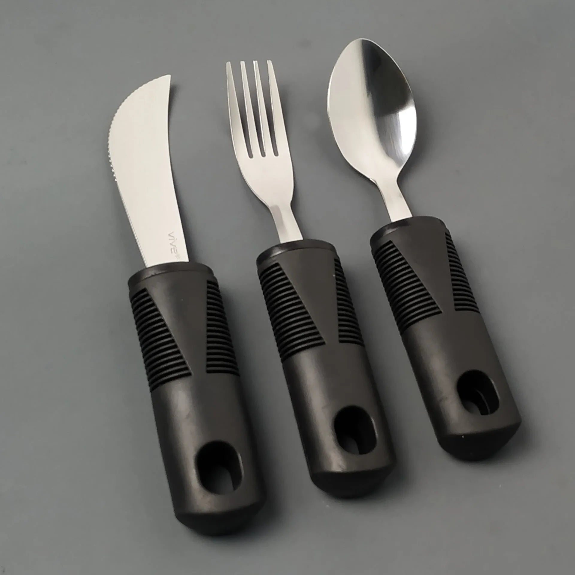 Adaptive cutlery set with stainless steel utensils and rubber grip handles for hand tremor assistance