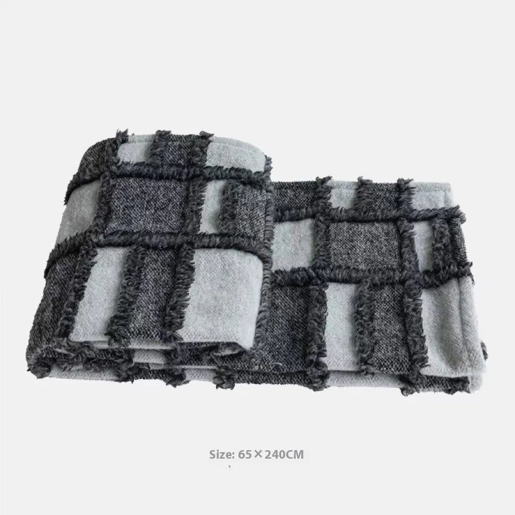 Modern minimalist plaid bed runner set with blanket, pillowcase, and round leather pillow on a bed