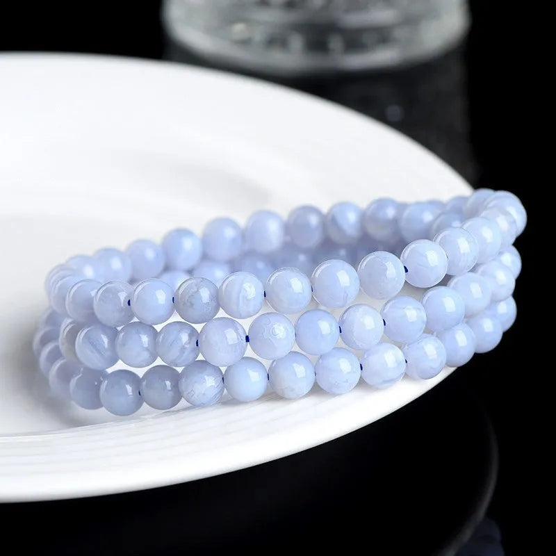 Blue agate bracelet with natural striped patterns, Ruyi design elements, and scattered bead arrangement
