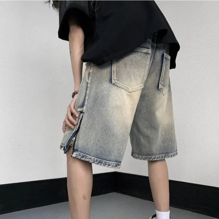 Blue retro tattered denim shorts with a wide leg and loose fit on a hanger.