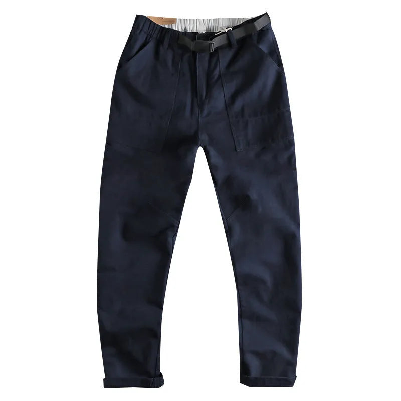 Men's khaki cotton work trousers with a black buckle belt and zip fly closure.