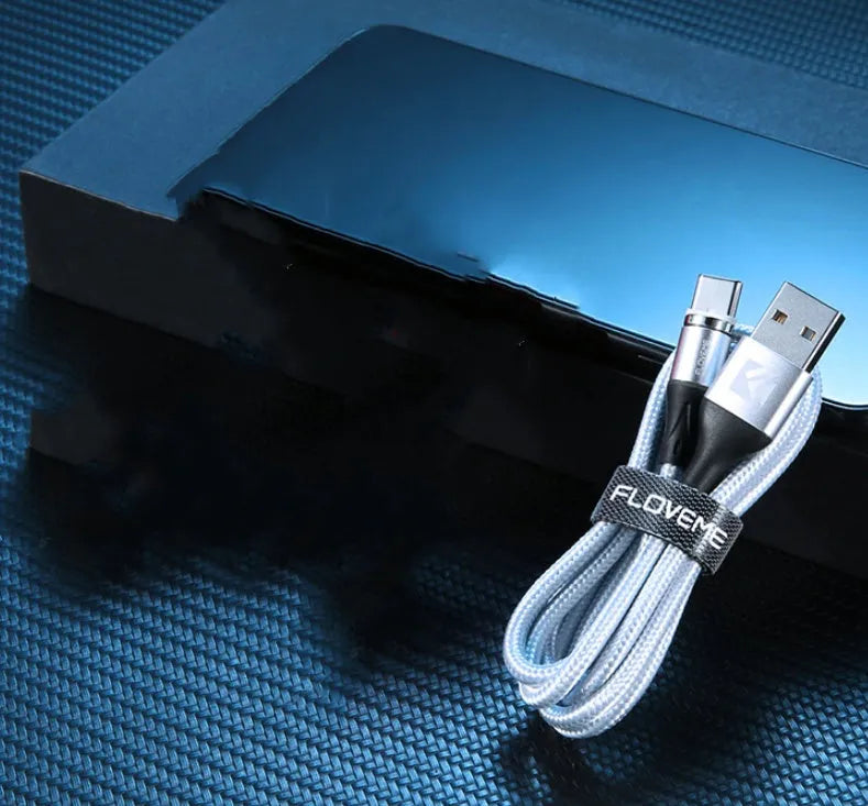 Black magnetic USB charging cable with illuminated side light on connector, next to smartphone.