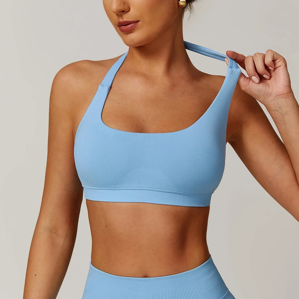 Women's black halter neck sports bra with medium support and hollow back.