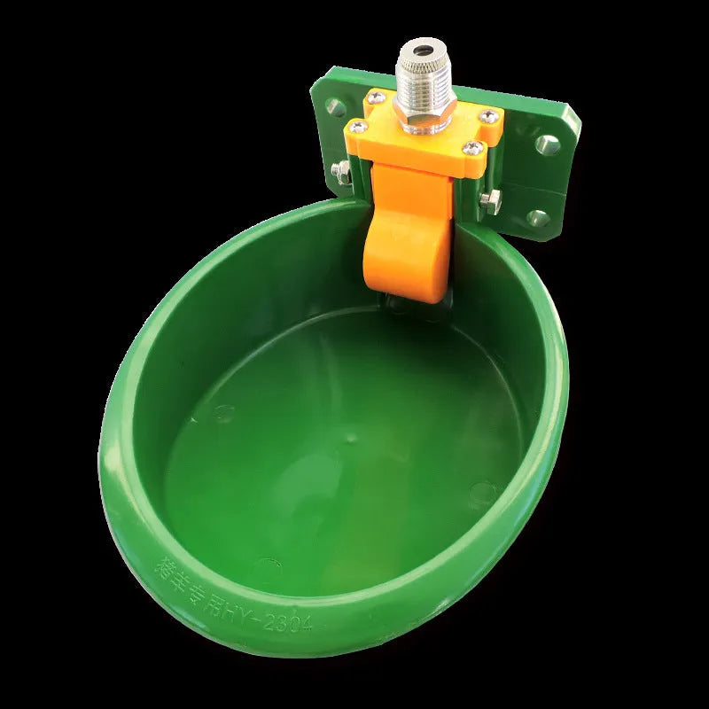 Green plastic drinking bowl for sheep and pigs on a farm.