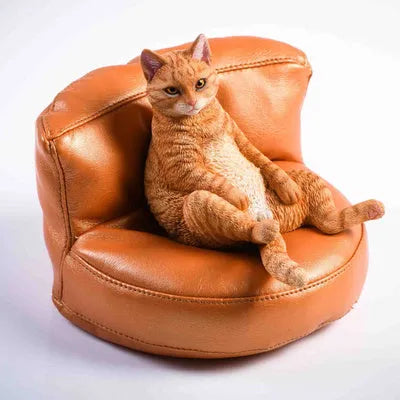 Small lazy cat car ornament and sofa, 7.5cm tall resin model on a car dashboard.
