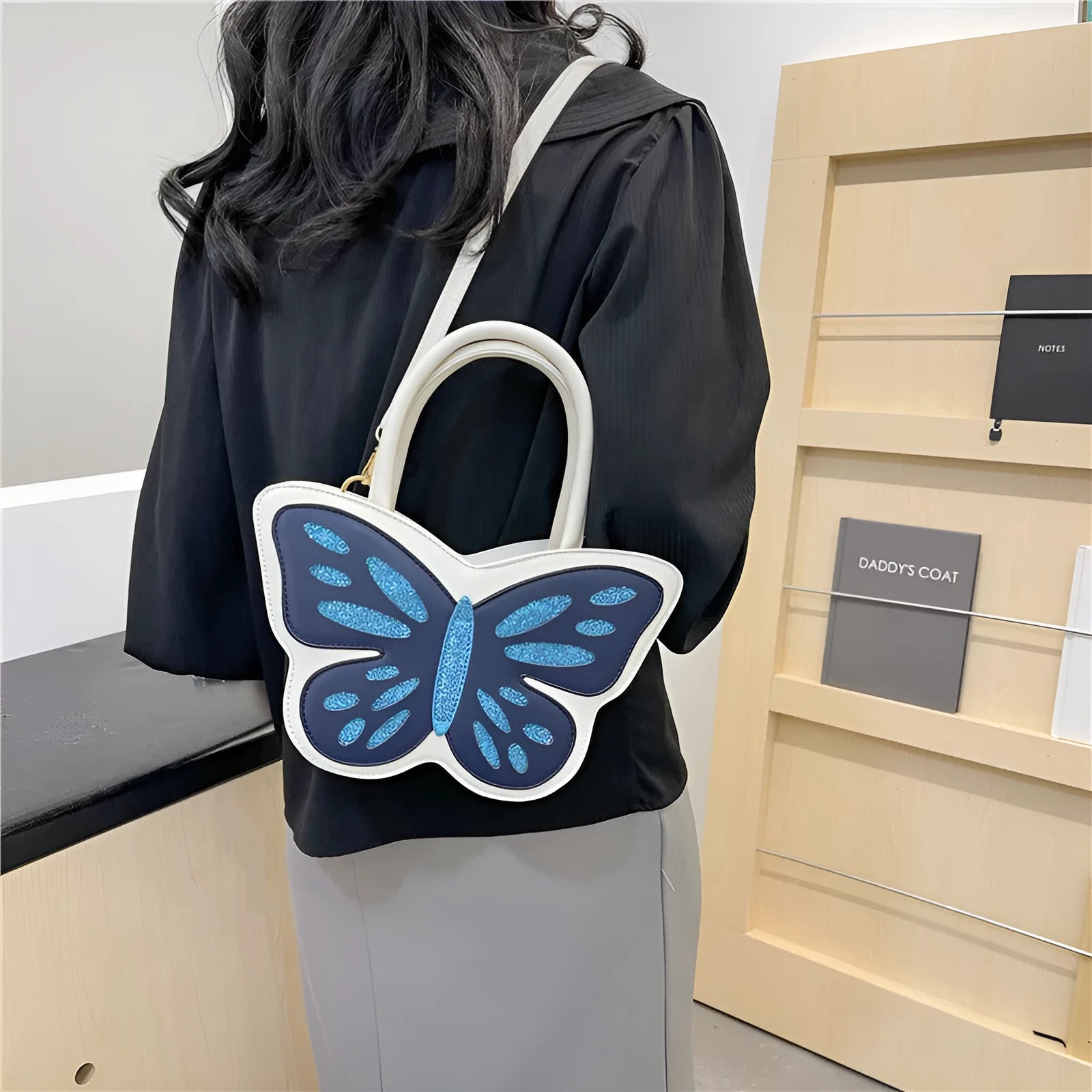 Square-shaped ladies crossbody bag in black with contrast colour detailing showing dimensions.