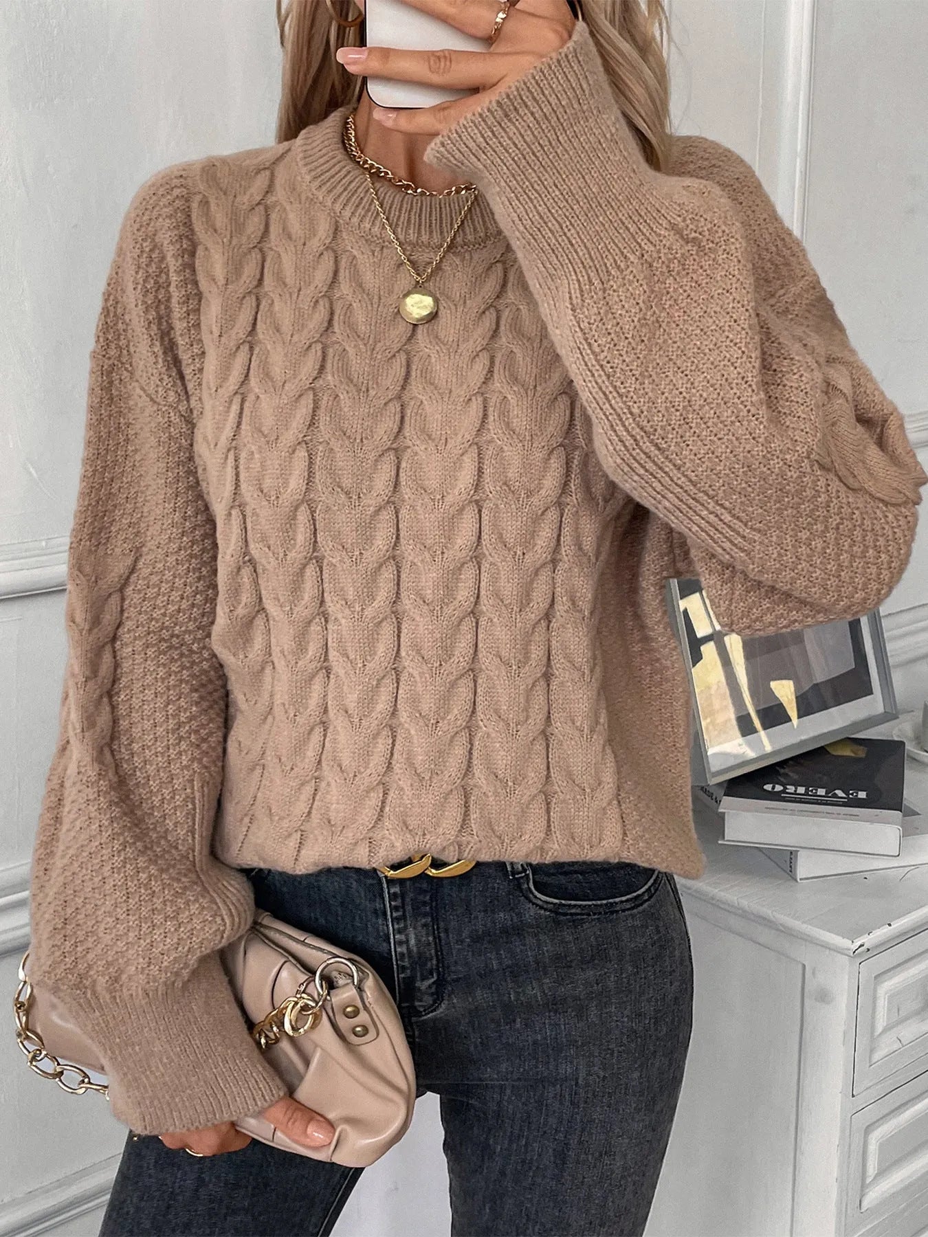Beige women's loose casual sweater with round neck and a subtle twist design detail on the front