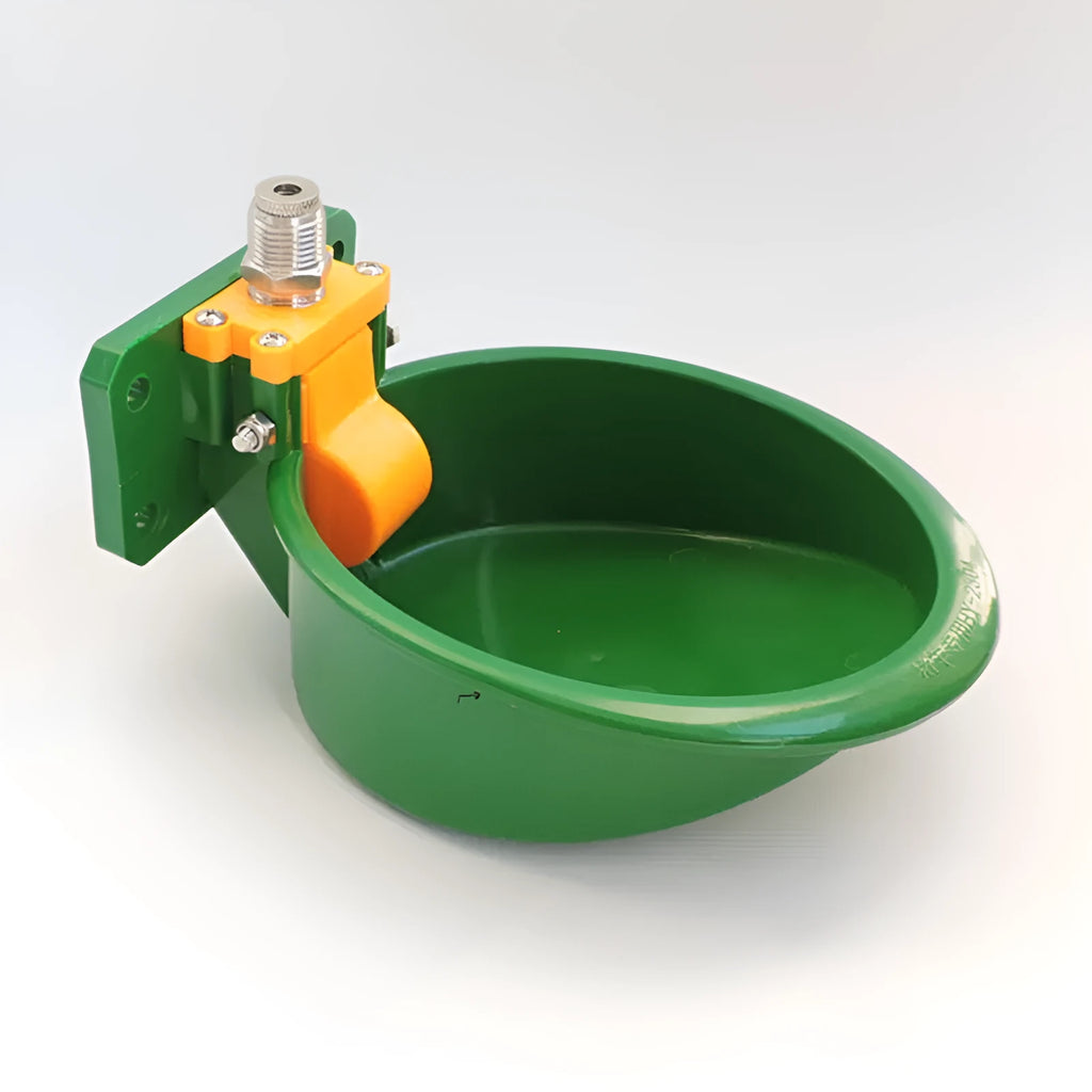 Green plastic drinking bowl for sheep and pigs on a farm.