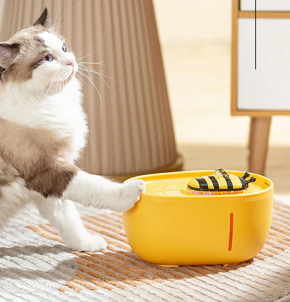 Yellow automatic cat water fountain with filter and USB cable on anti-slip base.