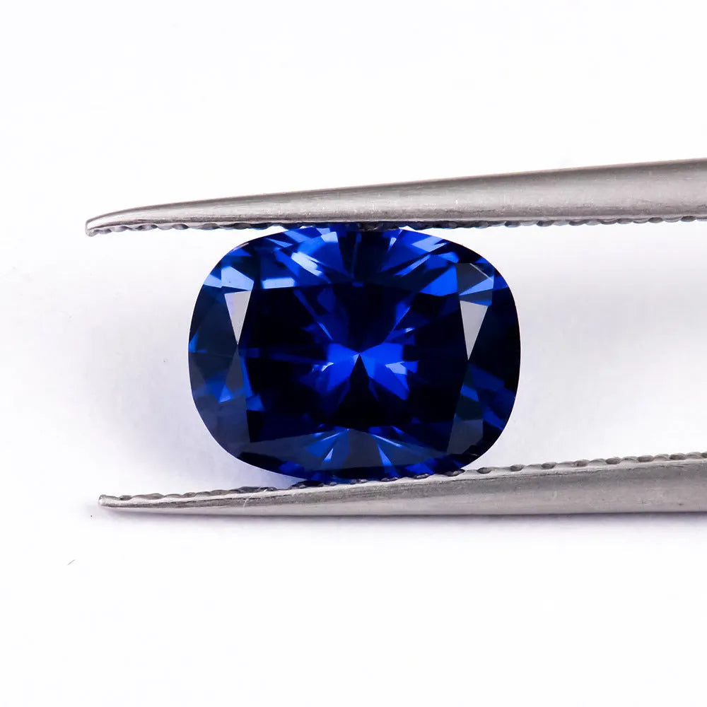 Royal blue loose gemstone in heart, round, and pear shapes on a white background.