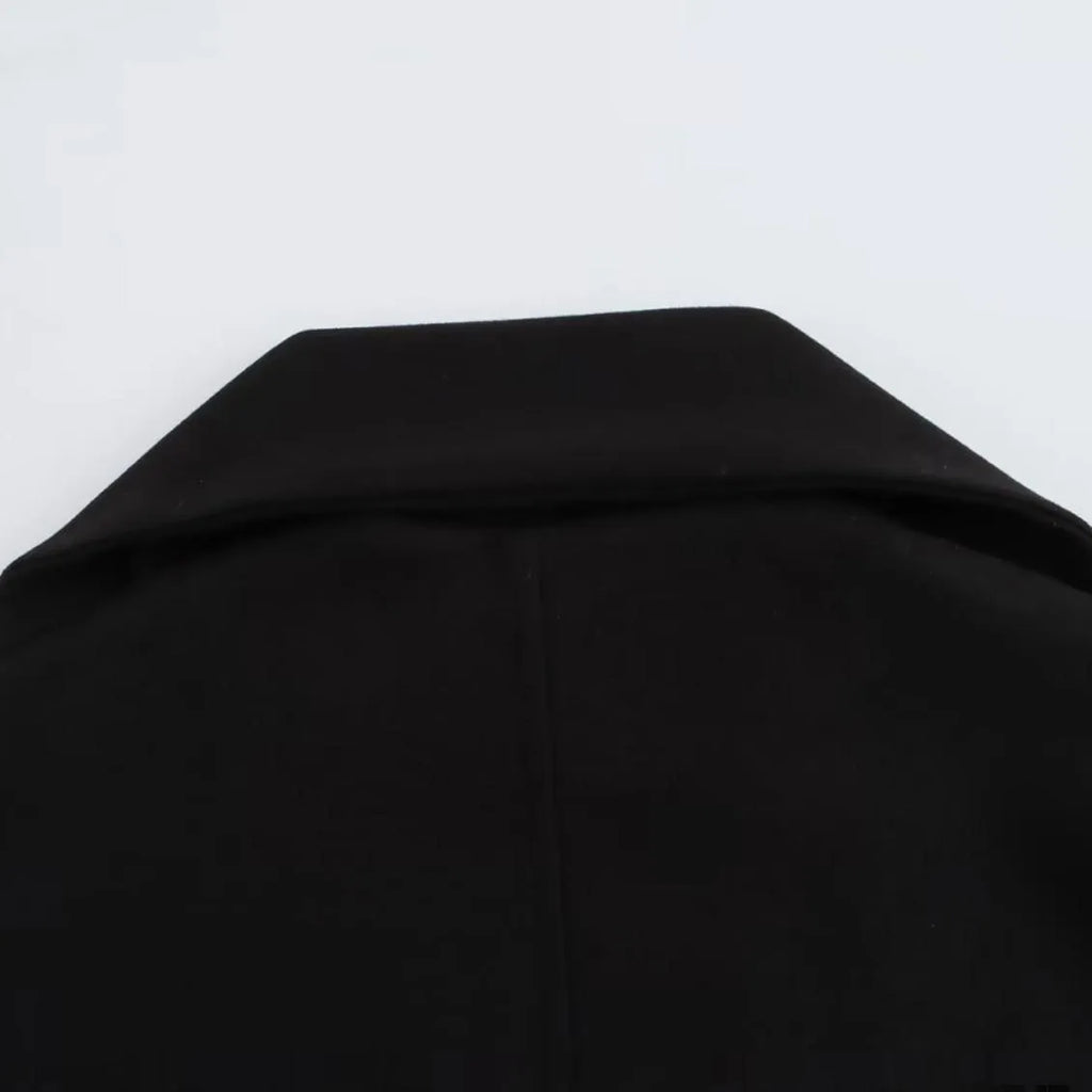 Women's long black polyester coat with a fluffy artificial fur collar, side pockets, and a street-fashion silhouette.