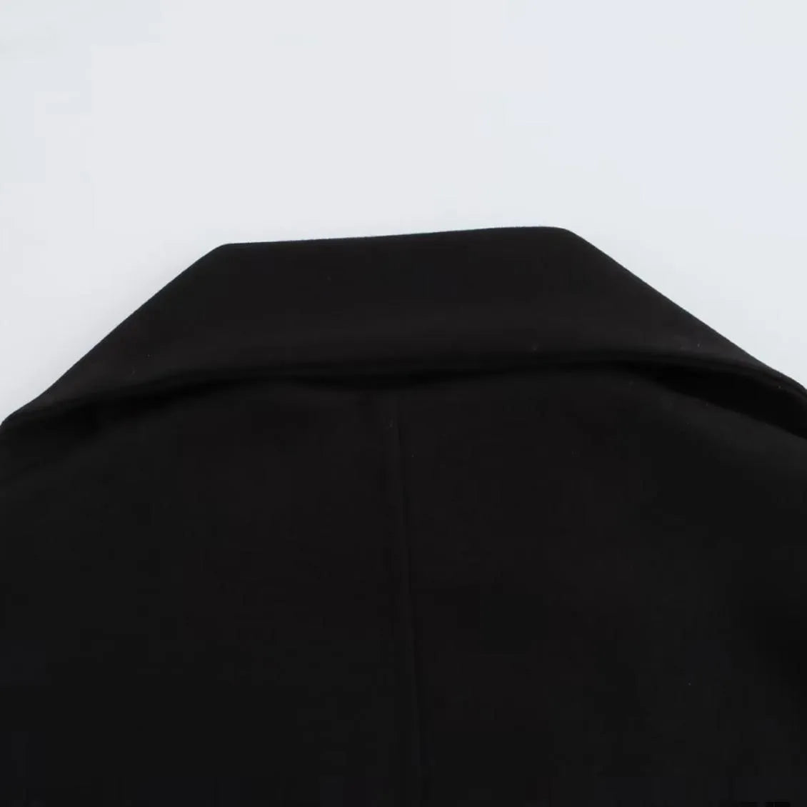 Women's long black polyester coat with a fluffy artificial fur collar, side pockets, and a street-fashion silhouette.