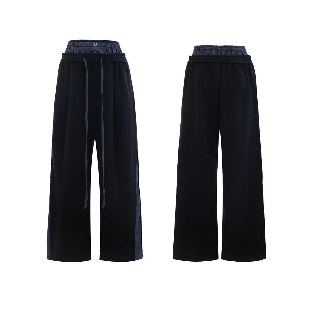 Men's black polyester sports suit with hooded short sleeve jacket and matching trousers laid flat